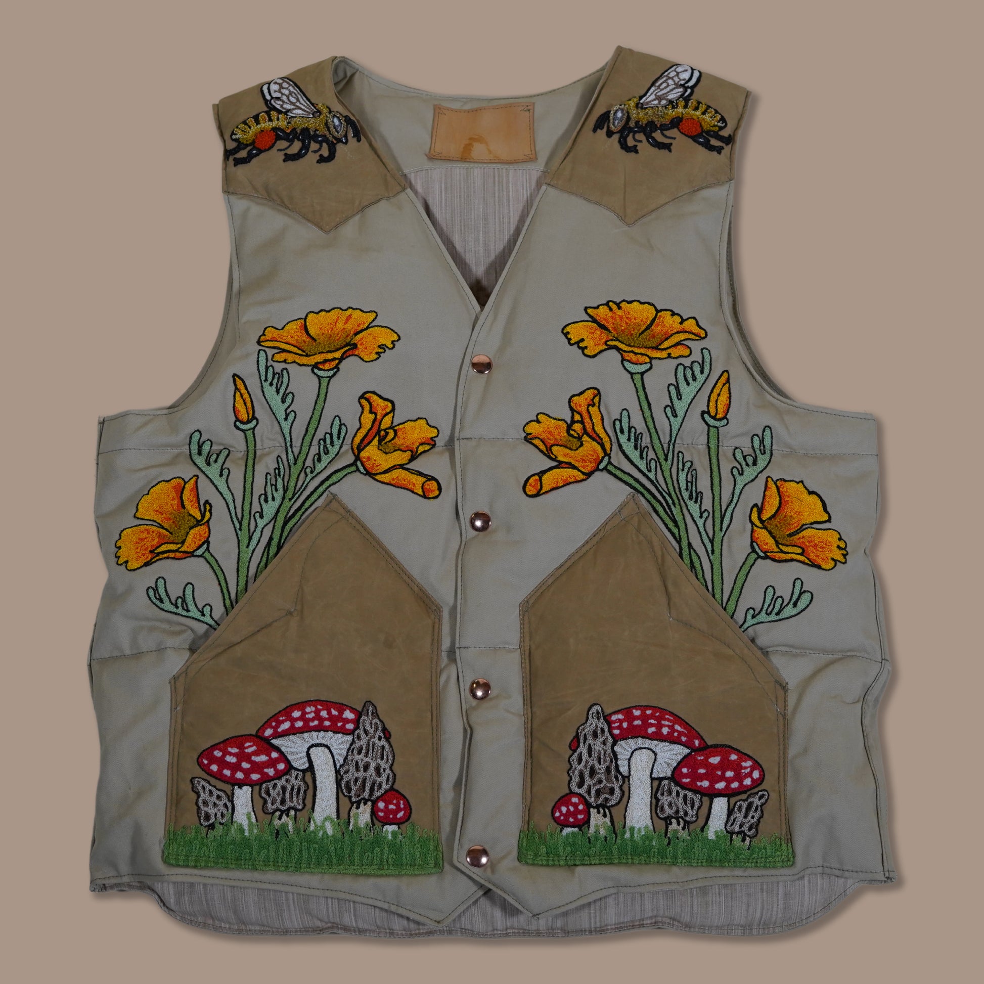 Custom embroidered and hand stuff down vest celebrating the rite or spring with poppys and mushrooms