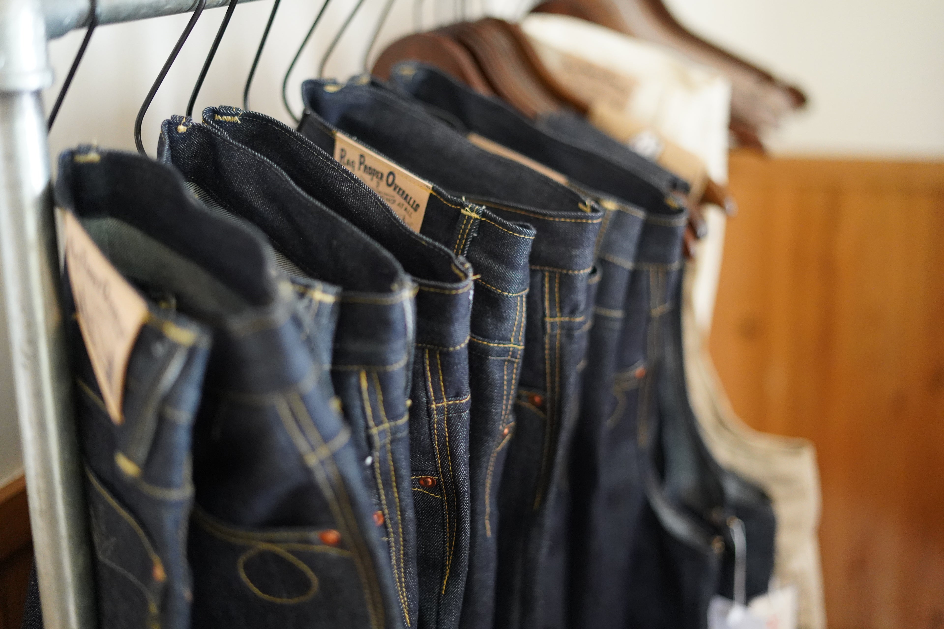 Racks of custom made hand tailored high rise straight leg denim by Rag Proper Overalls